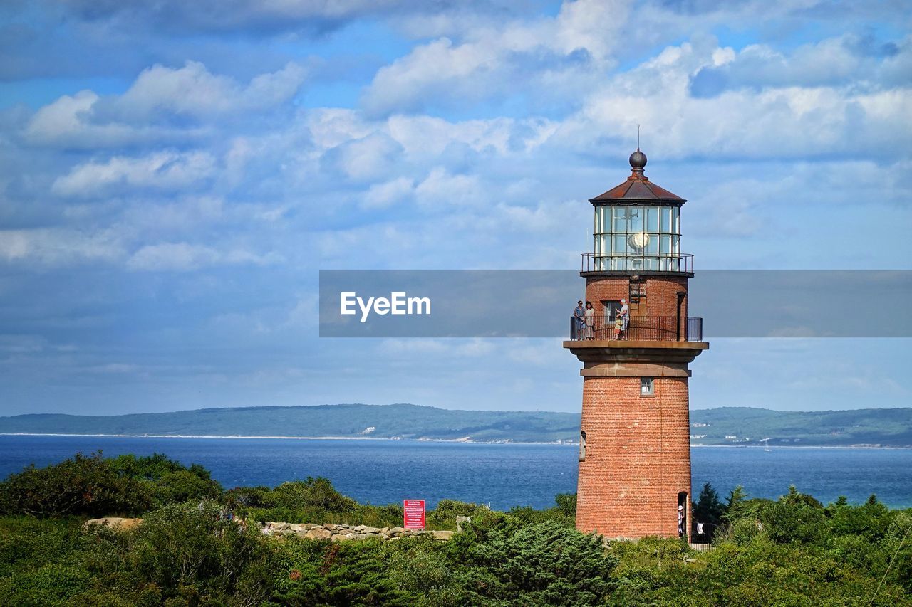 LIGHTHOUSE BY SEA AGAINST SKY AND BUILDING