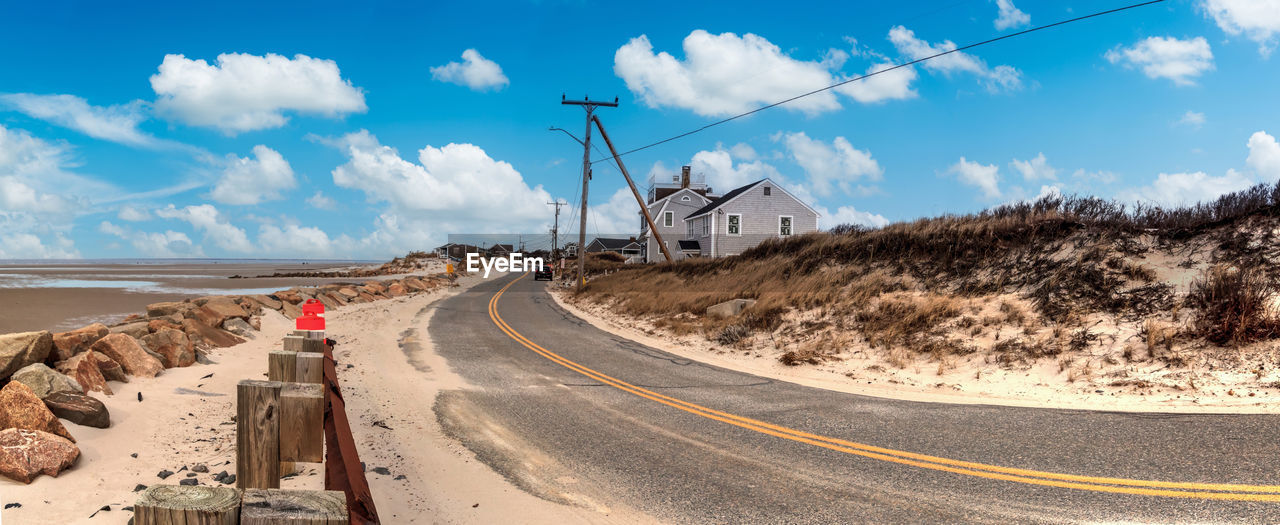 Blue sky over roadway along chapin beach in cape cod, massachusetts.