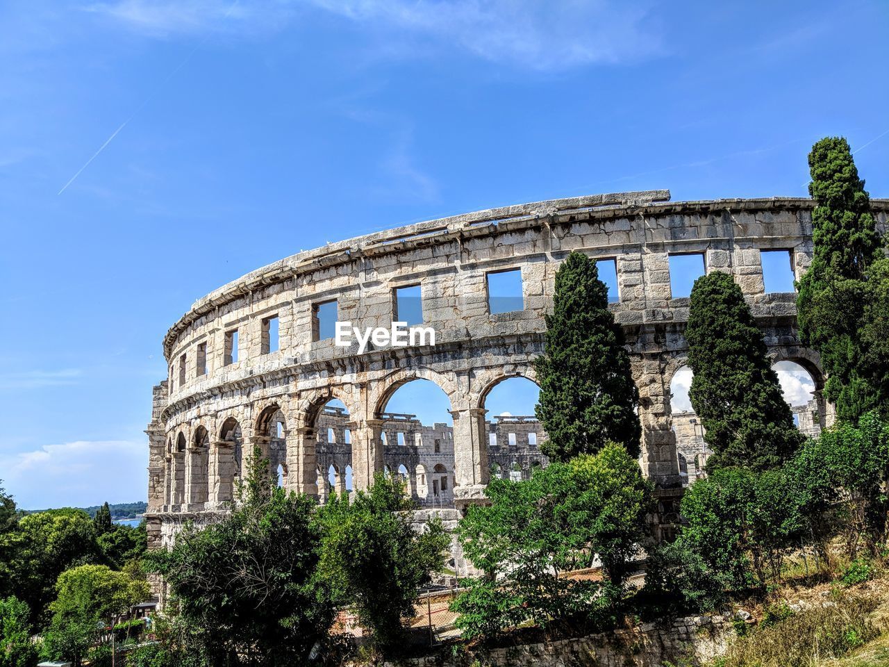 Low angle view of amphitheater and trees against sky