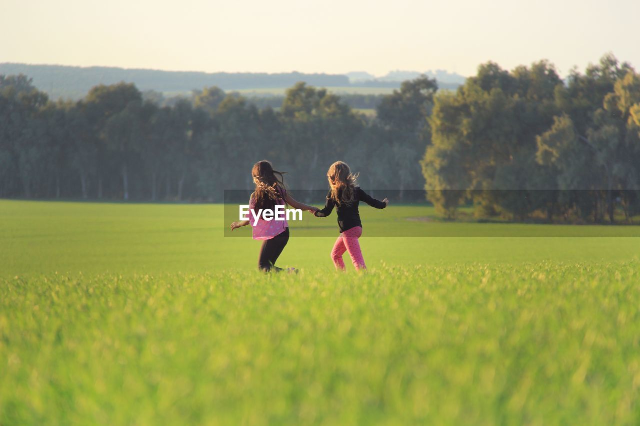 FULL LENGTH OF GIRL PLAYING ON GRASSY FIELD