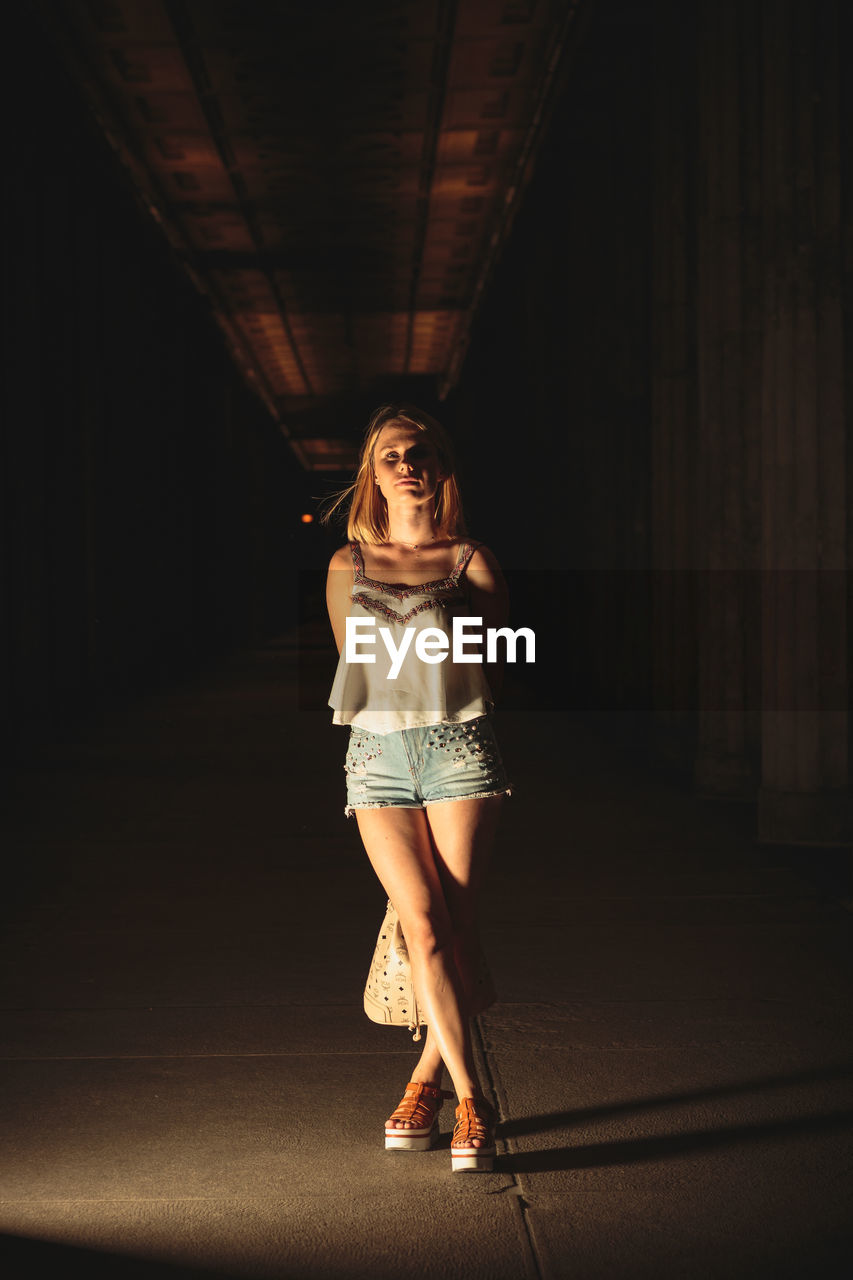 Portrait of young woman standing at parking garage