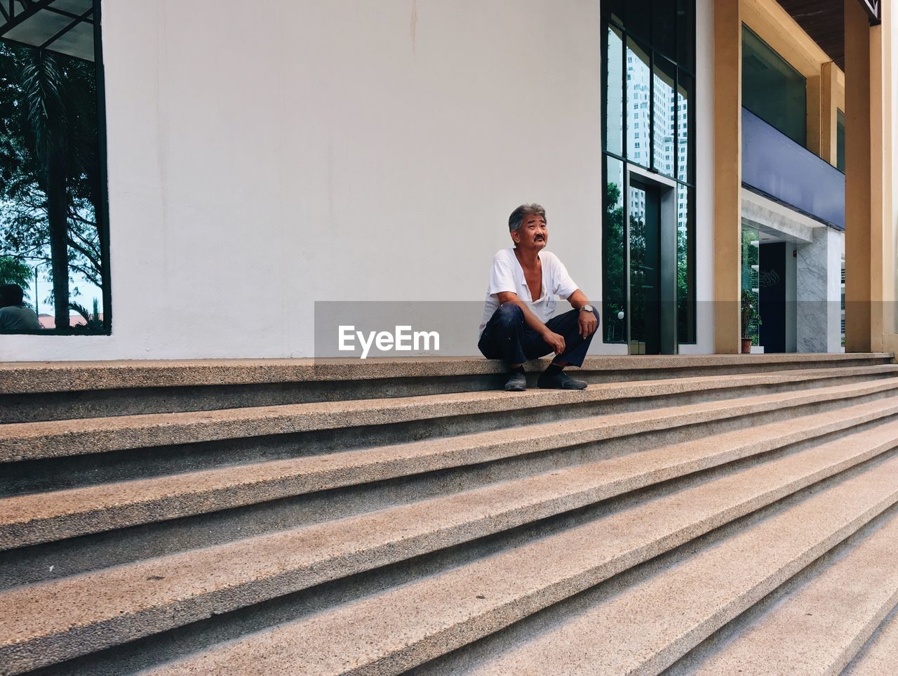 FULL LENGTH OF WOMAN SITTING ON STEPS