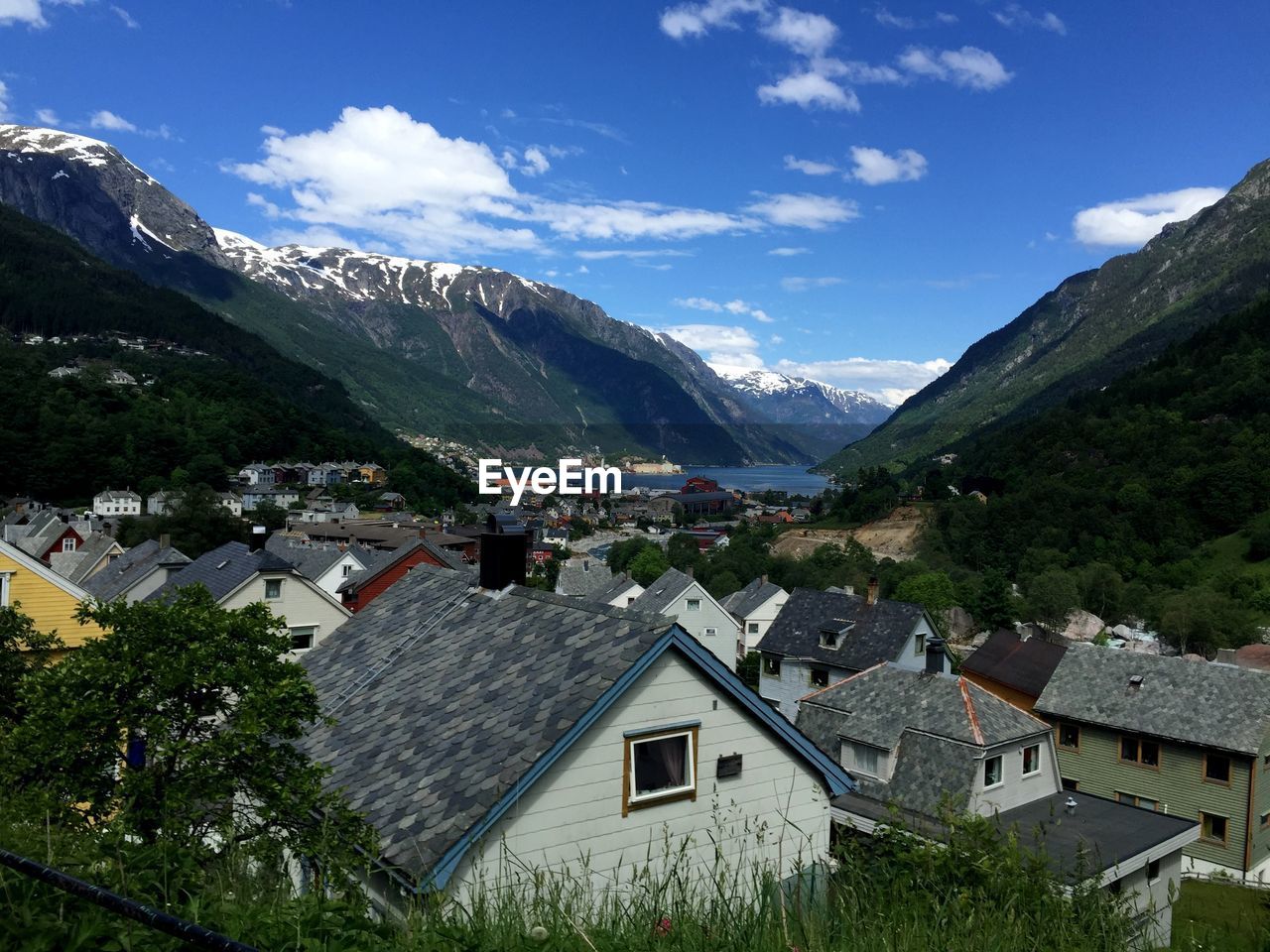 Houses by mountains against blue sky