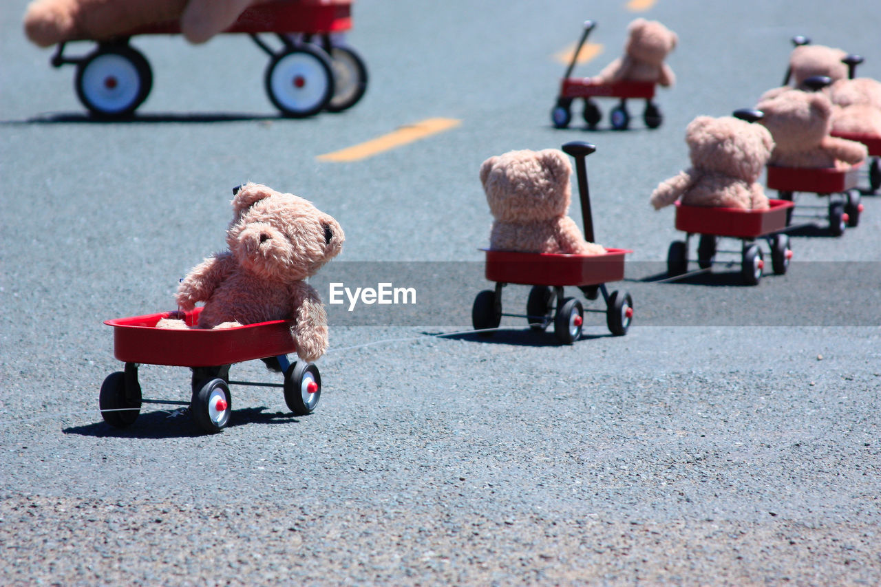 Teddy bears in toy cars on road