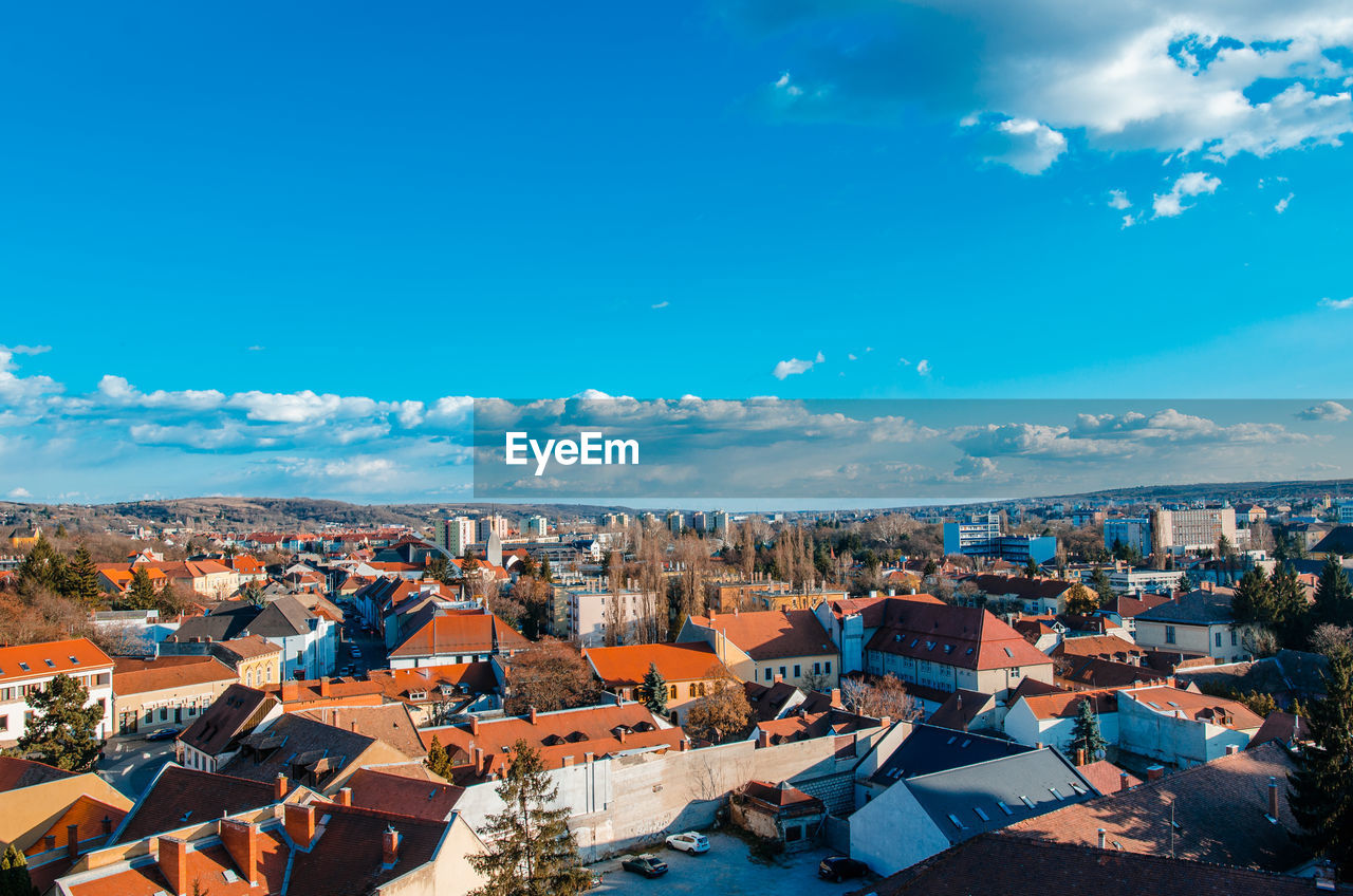 HIGH ANGLE SHOT OF TOWNSCAPE AGAINST BLUE SKY