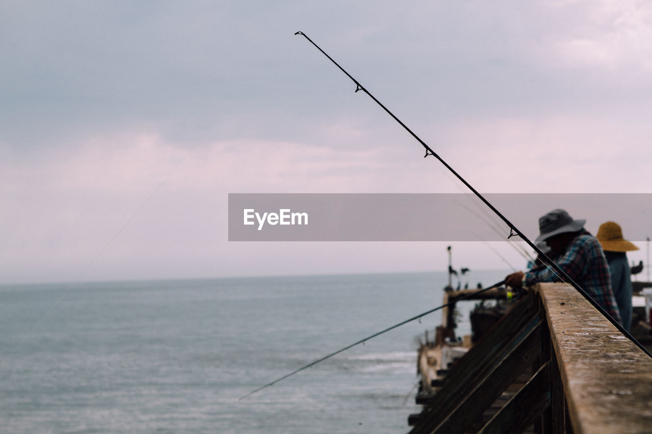 People fly-fishing in sea