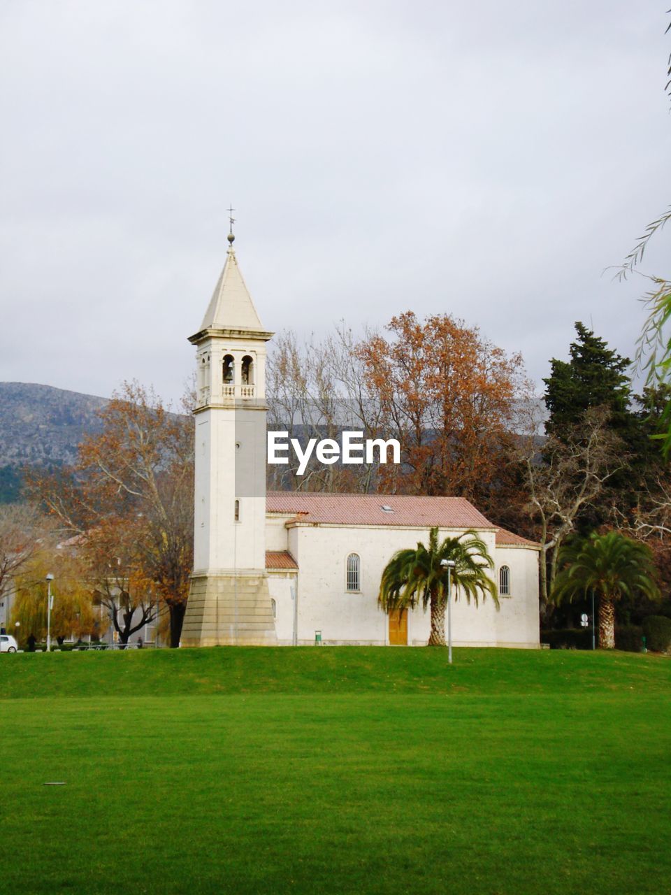 Church on field by building against sky