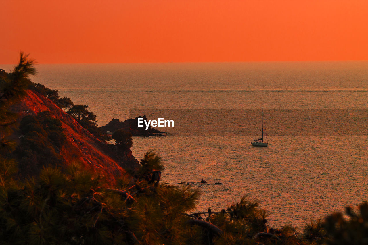 Scenic view of sea against orange sky