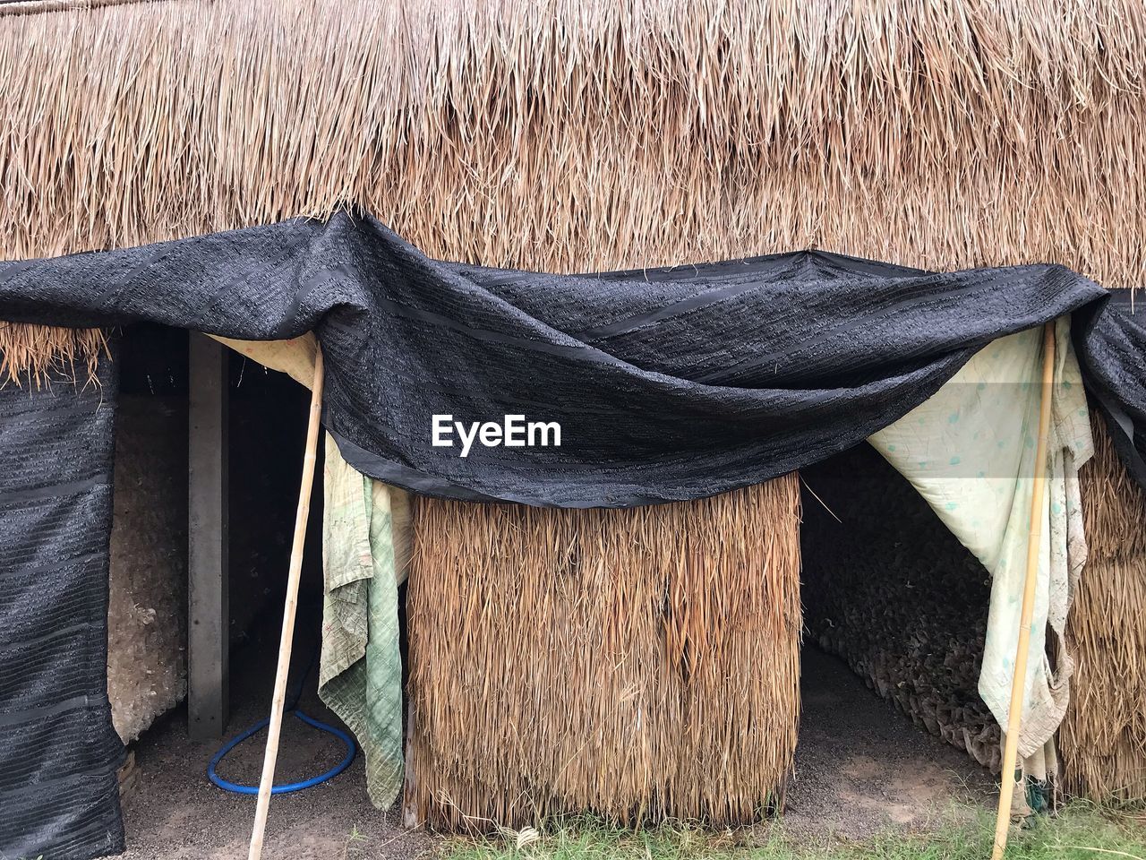 CLOSE-UP OF CLOTHES DRYING ON CLOTHESLINE OUTSIDE HOUSE