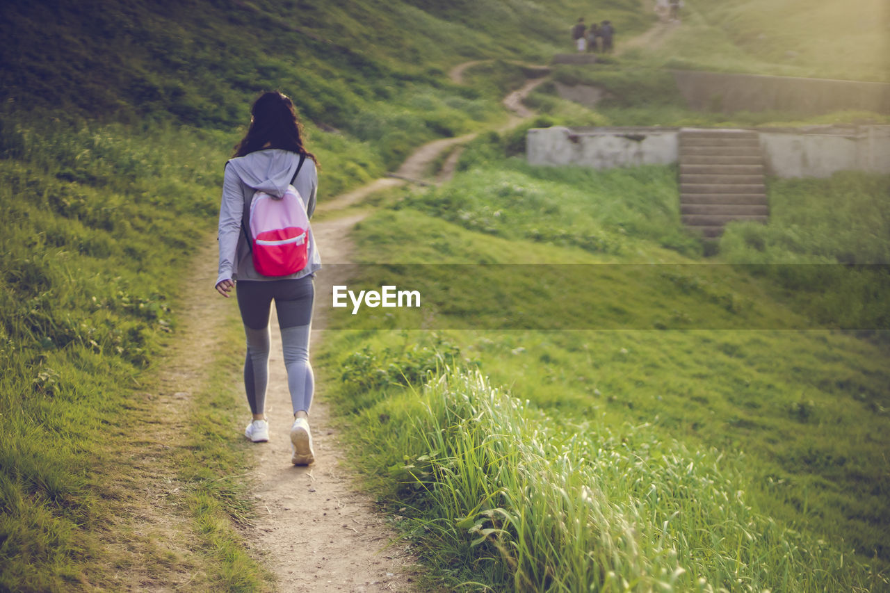 Rear view of woman walking on footpath