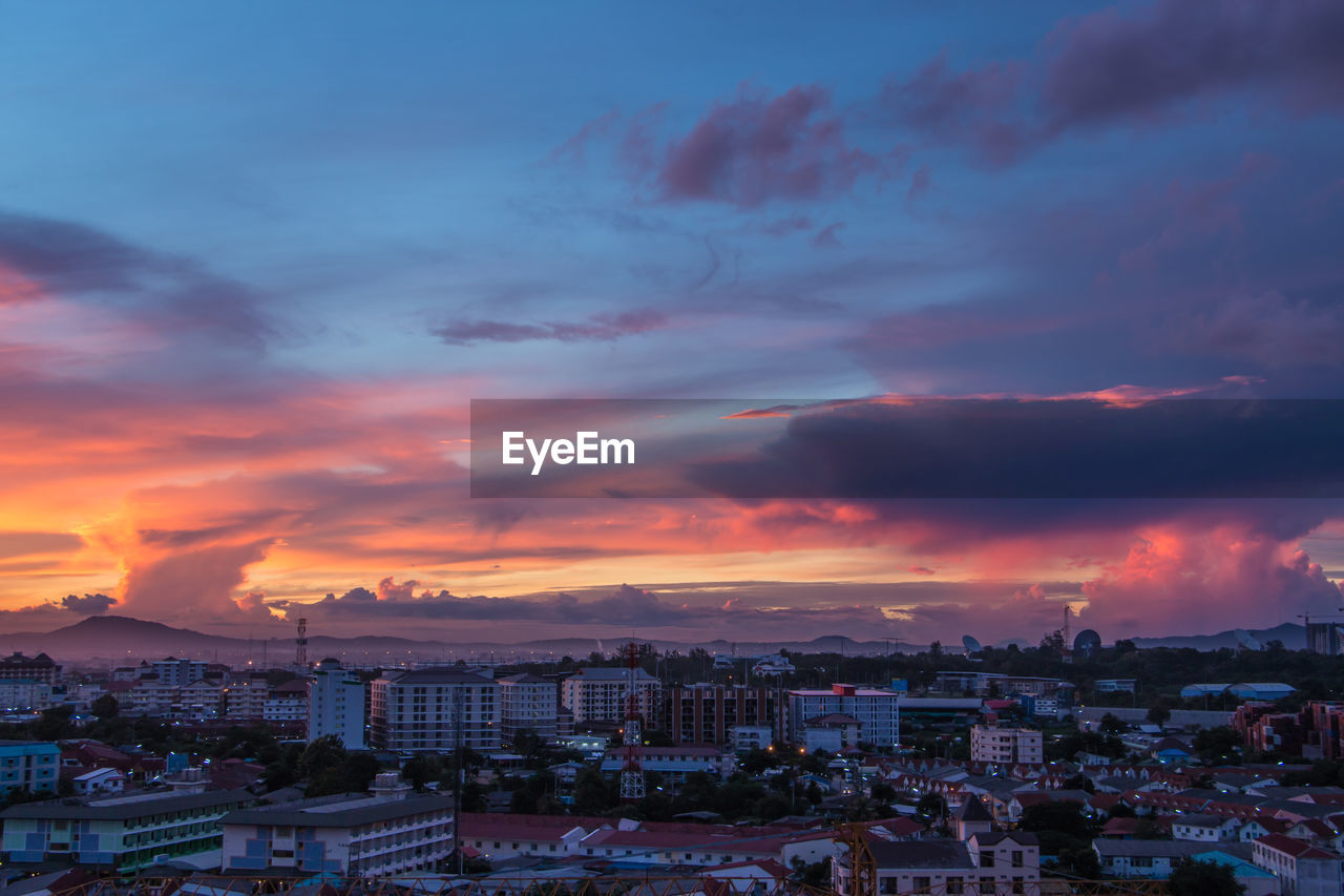 HIGH ANGLE SHOT OF TOWNSCAPE AGAINST SKY AT SUNSET