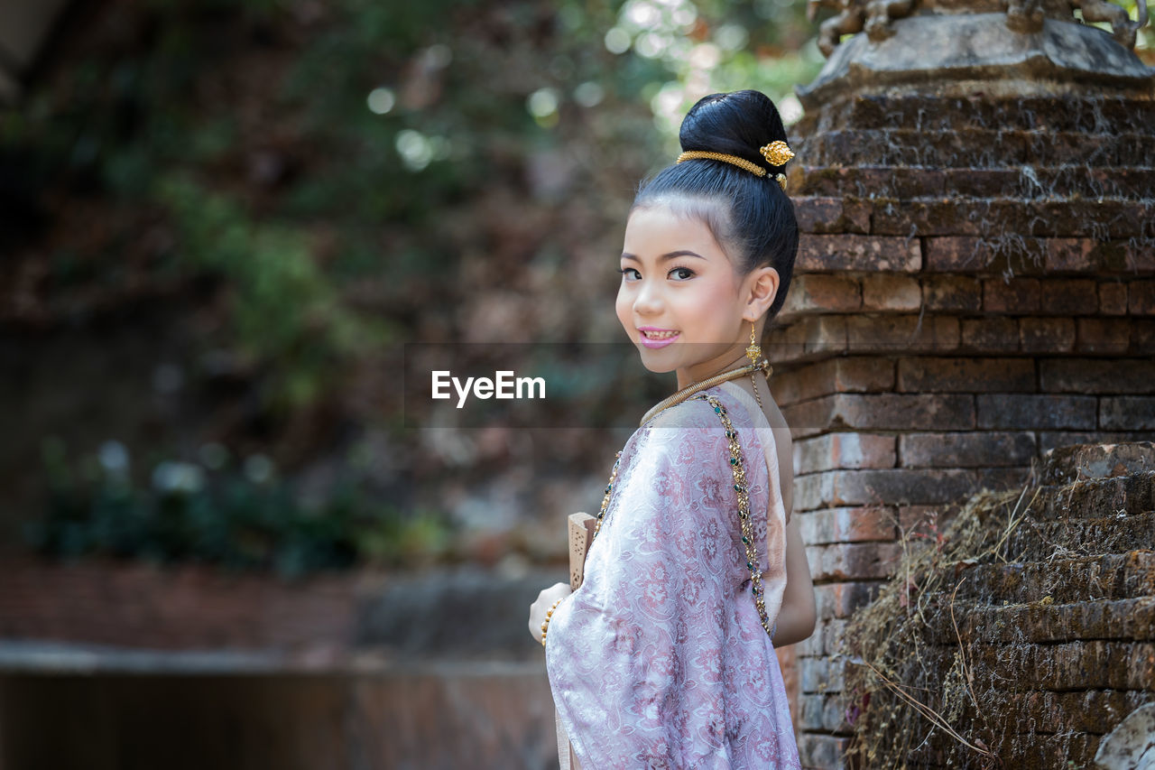 Portrait of smiling girl standing outdoors