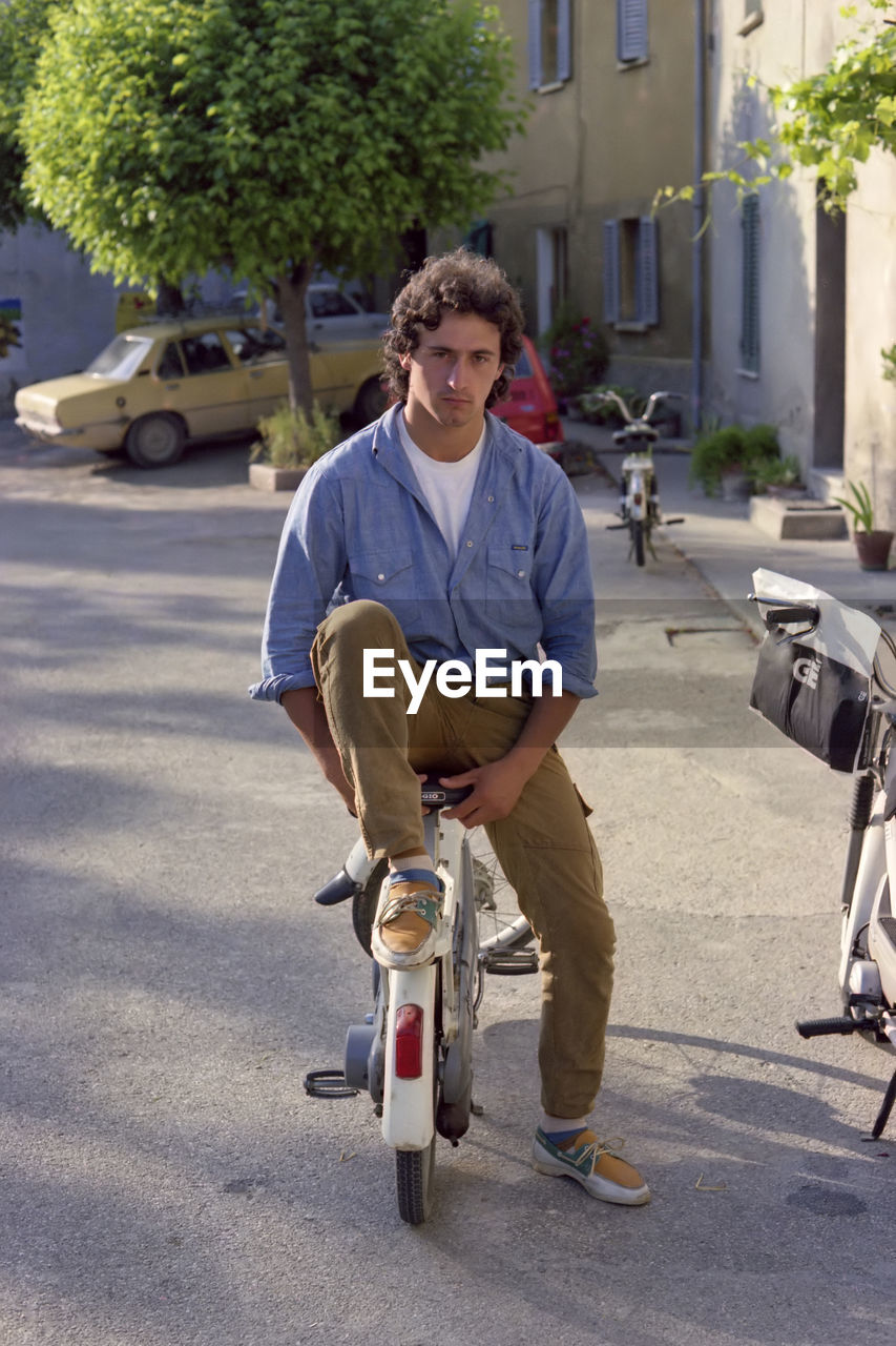 Man riding push scooter on street