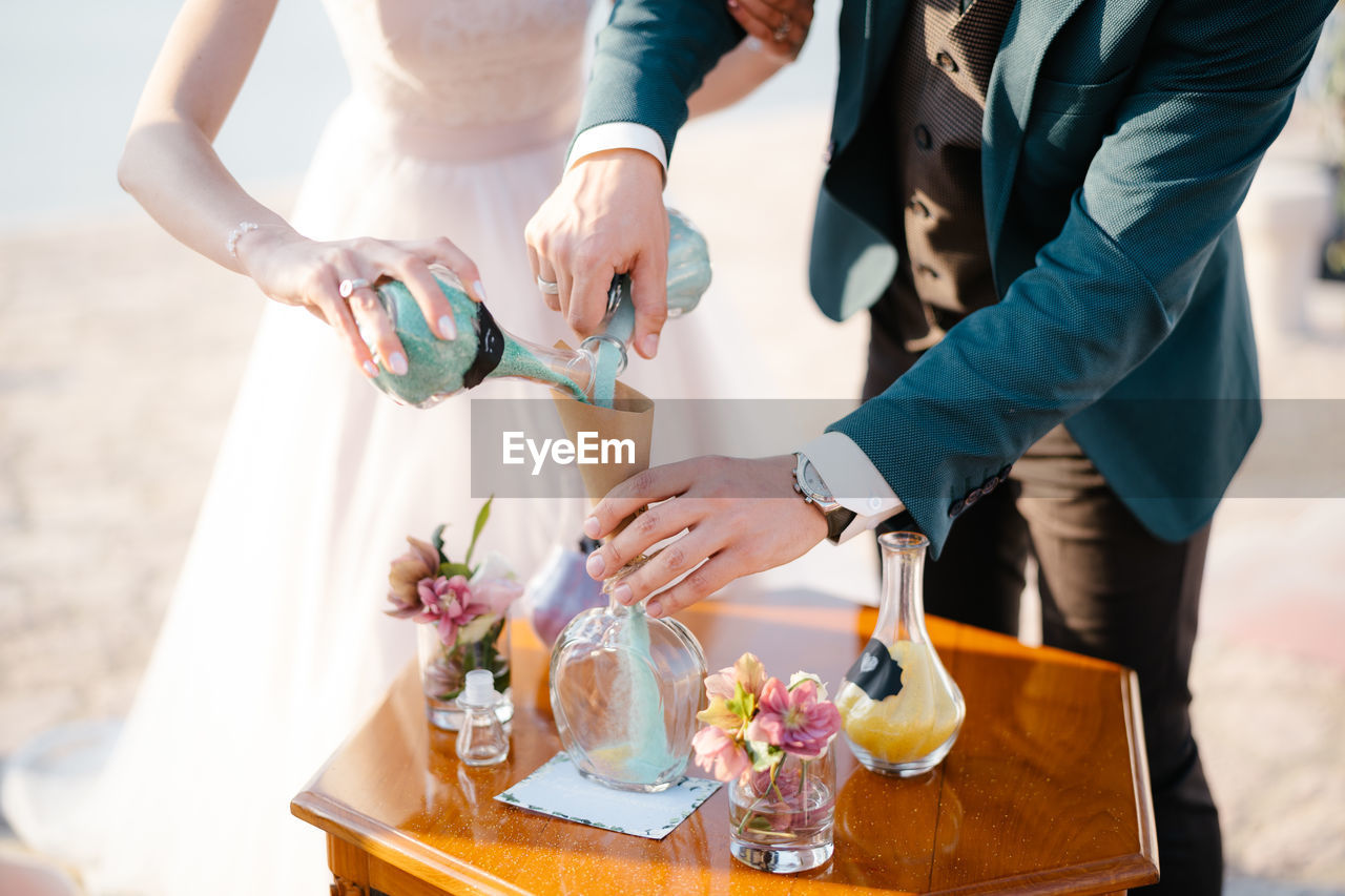 Midsection of bride and groom preparing food