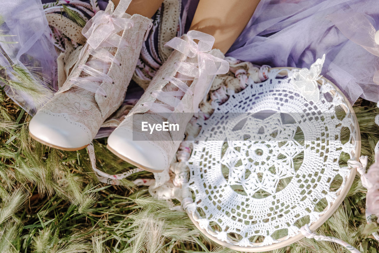 LOW SECTION OF WOMAN WEARING CANVAS SHOES IN BAG