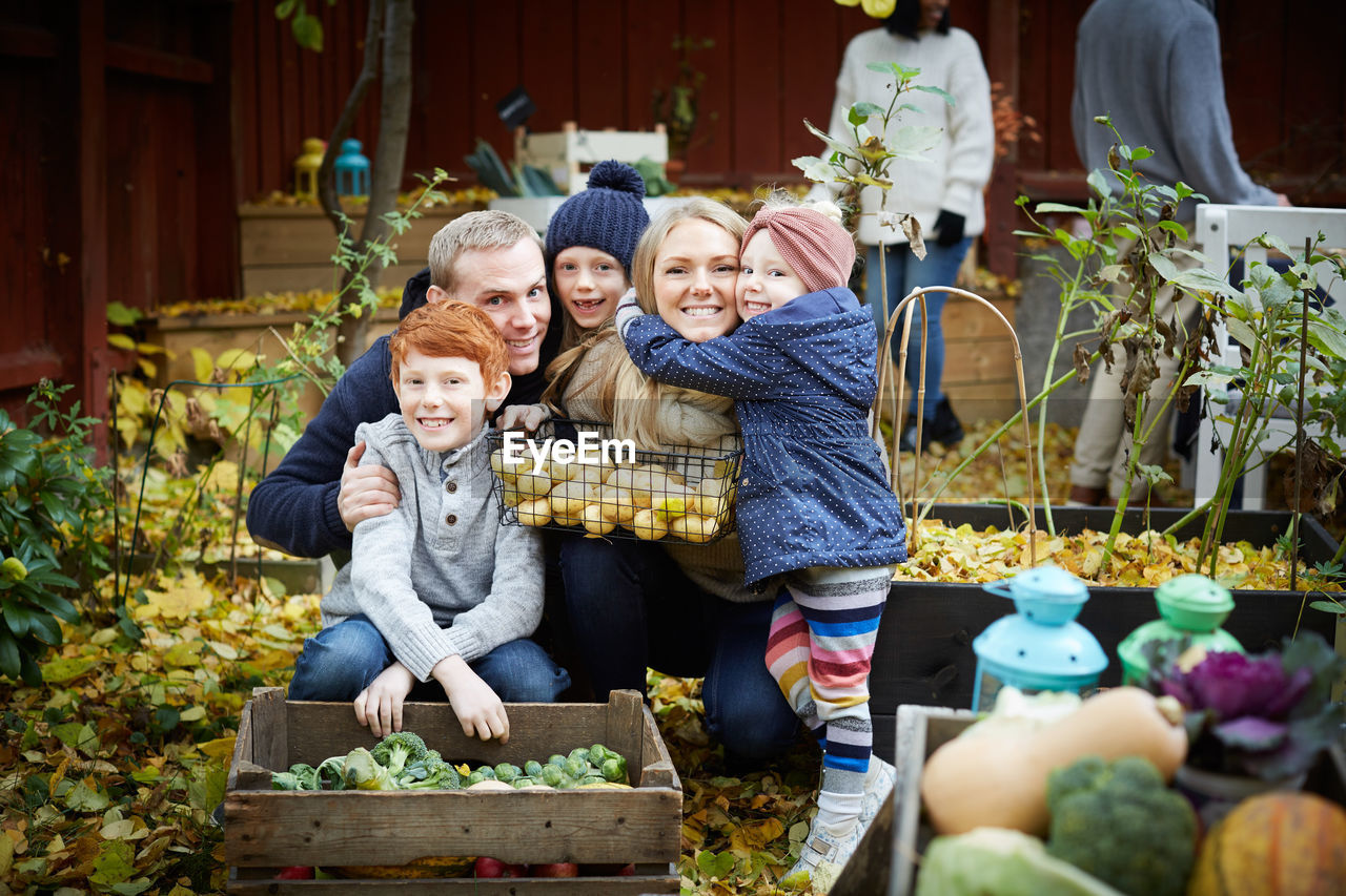 Portrait of happy family with fresh produce in back yard