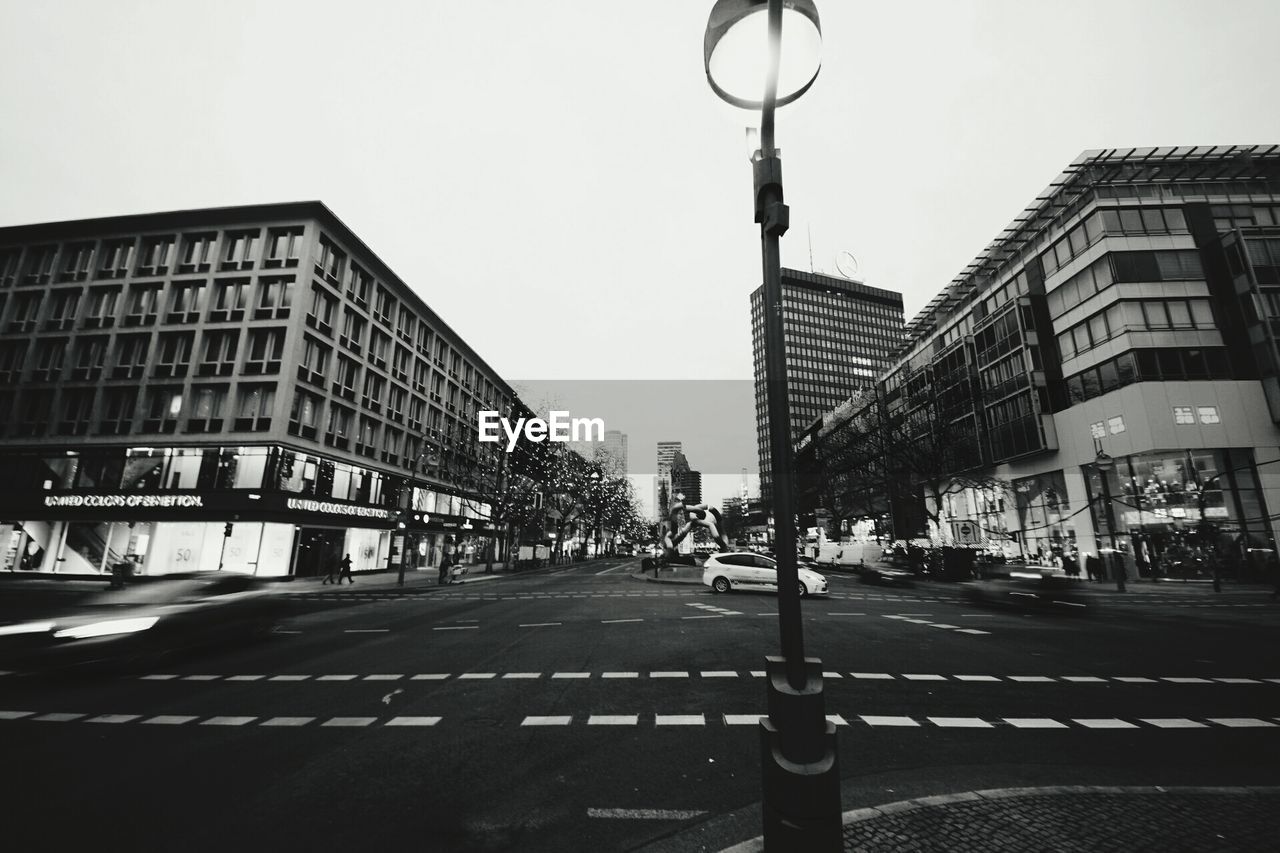 LOW ANGLE VIEW OF CITY STREET AGAINST CLEAR SKY