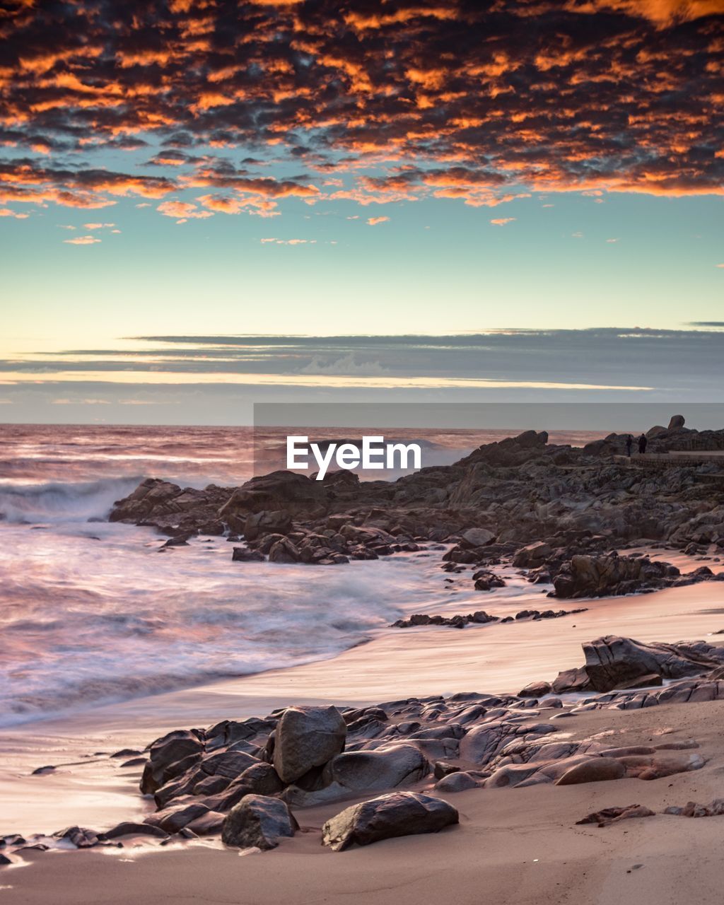 Scenic view of sea against cloudy sky during sunset