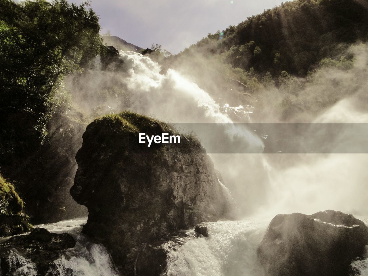 Scenic view of waterfall against sky