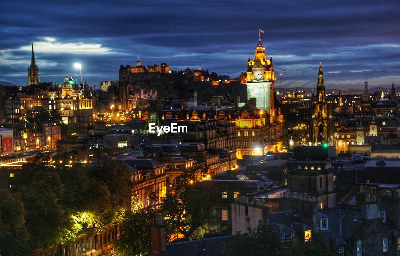HIGH ANGLE VIEW OF ILLUMINATED BUILDINGS IN CITY