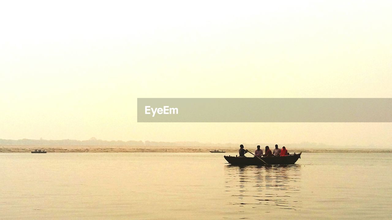 BOAT SAILING IN SEA DURING SUNSET