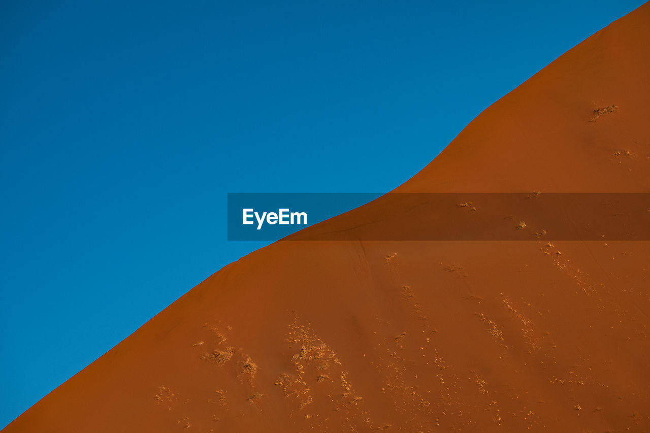 Sand dune profile against blue sky in namib desert 