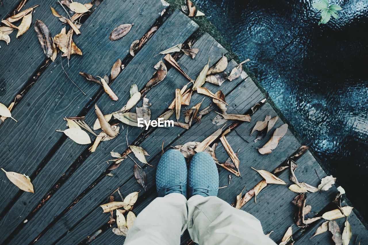 Low section of man standing on boardwalk