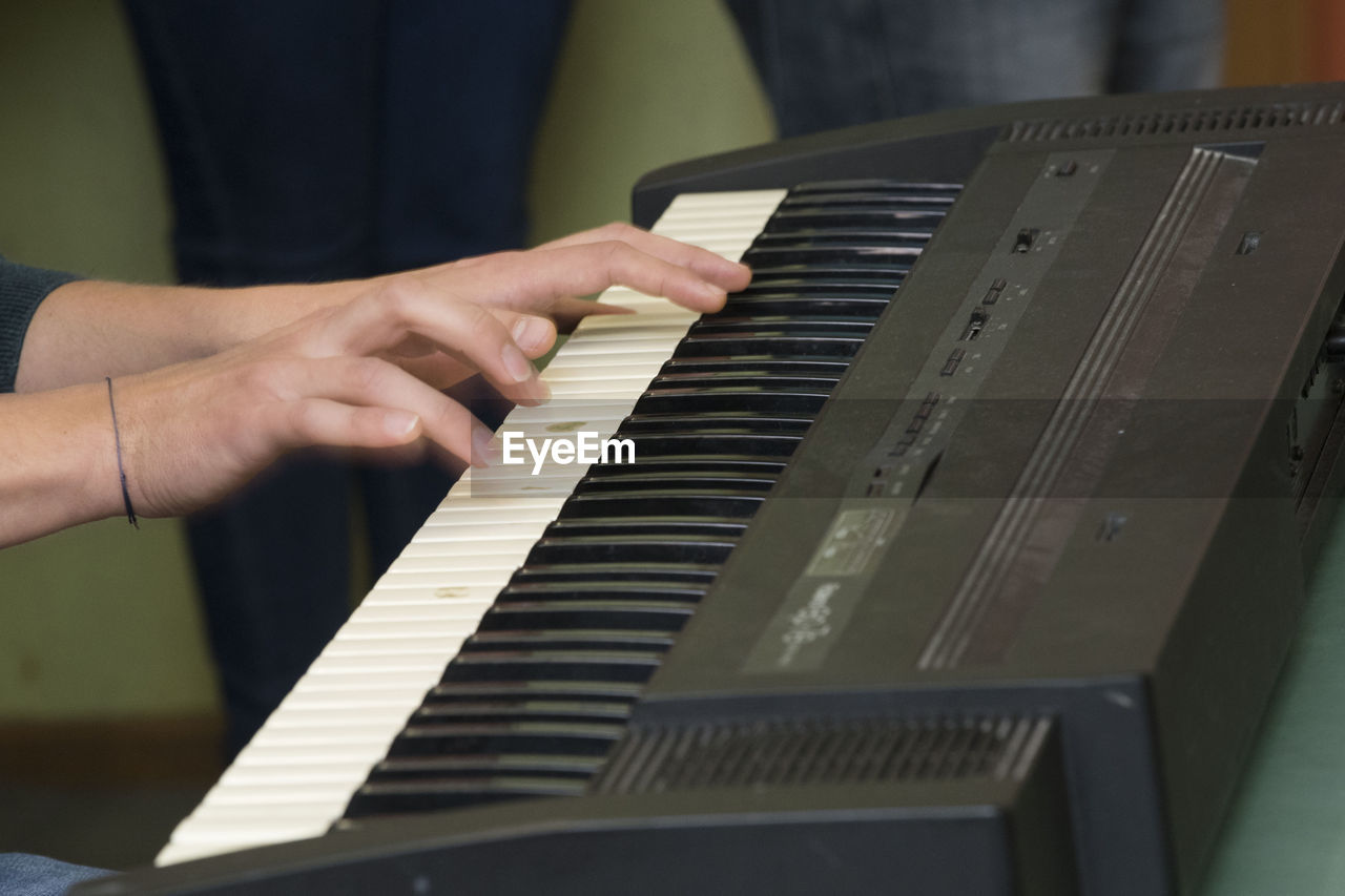 CROPPED IMAGE OF MAN PLAYING PIANO