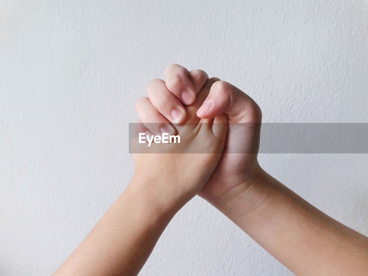 CLOSE-UP OF WOMAN HAND ON WHITE WALL