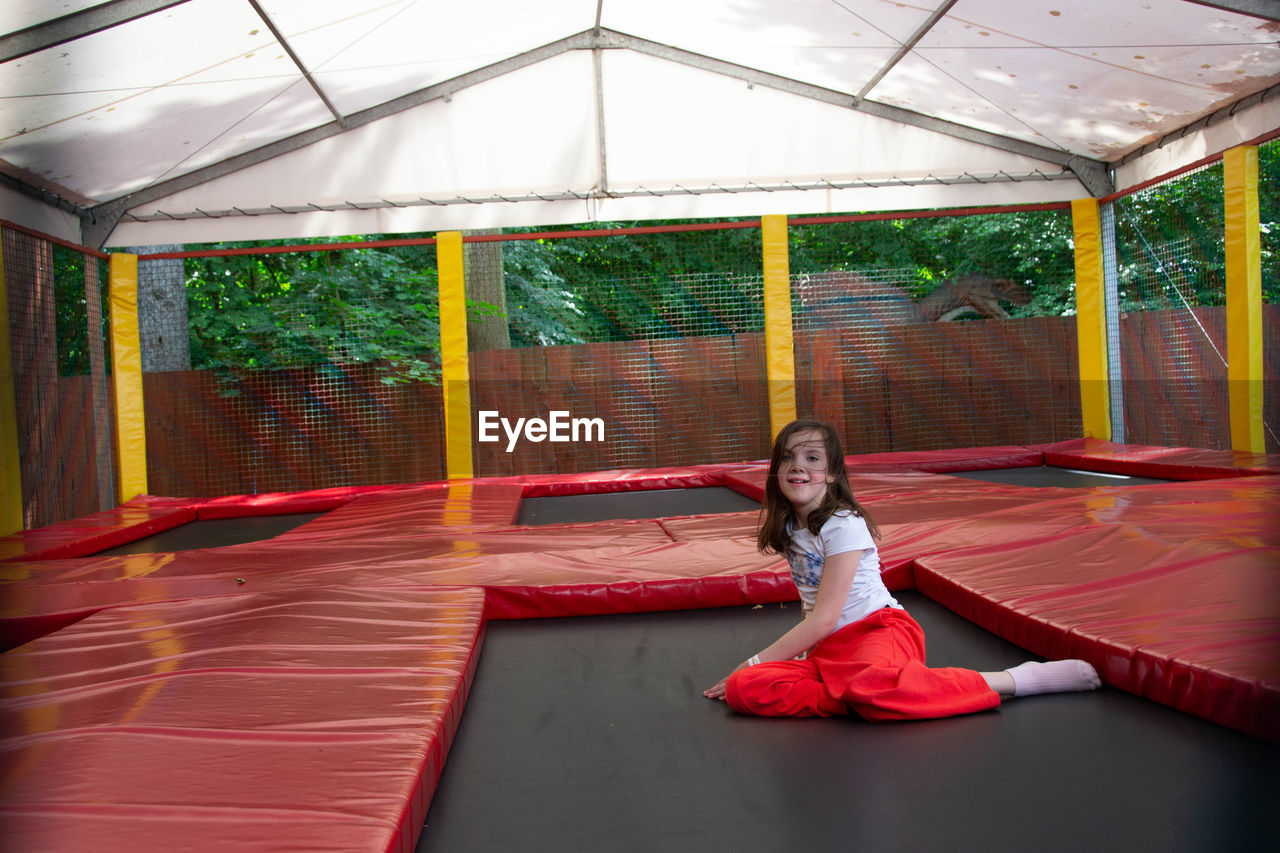 Happy lsports girl having fun while jumping on trampoline