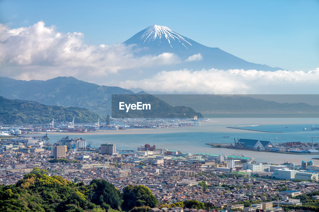 Aerial view of city against cloudy sky