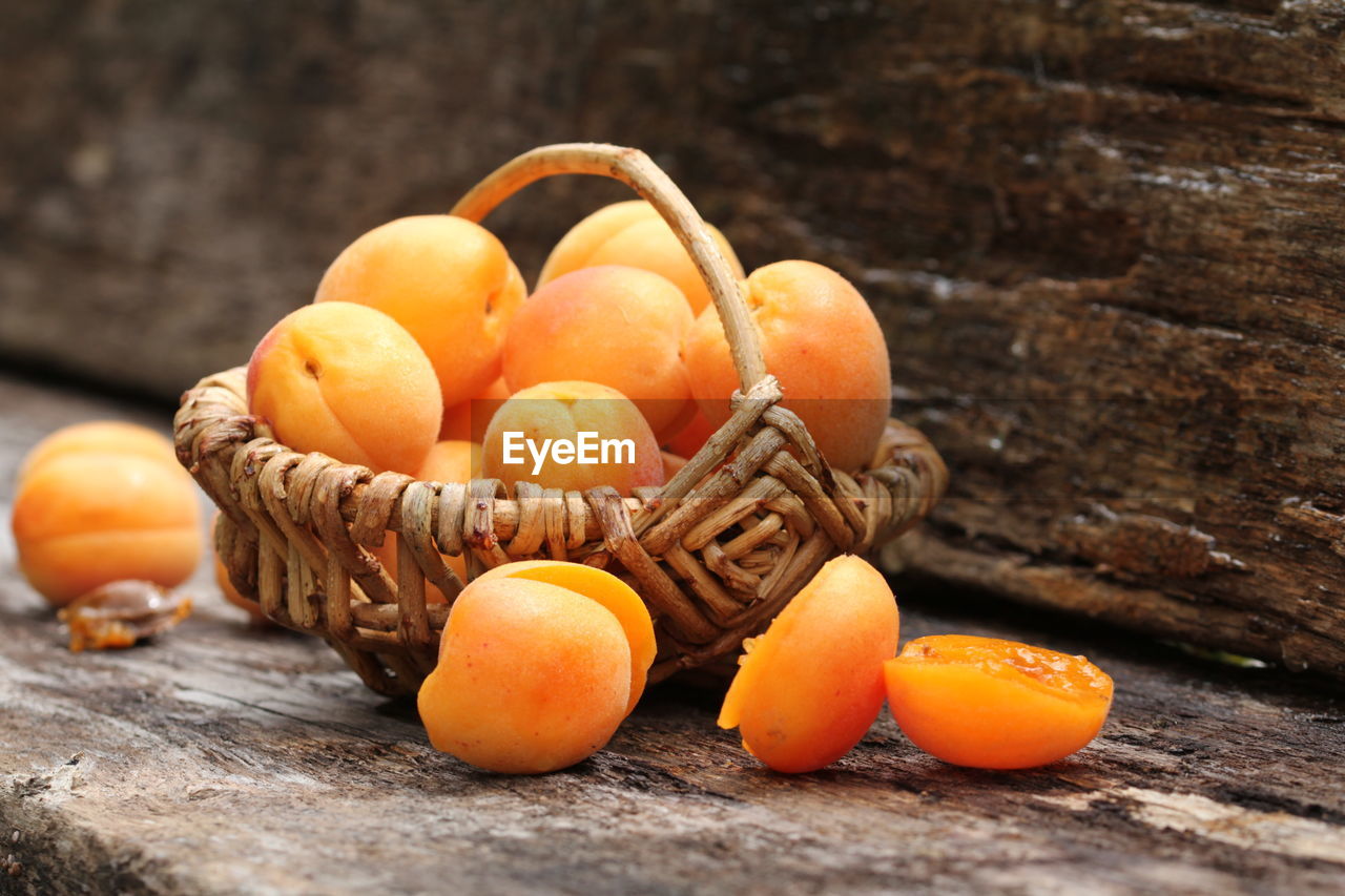 Apricots in wicker basket on table