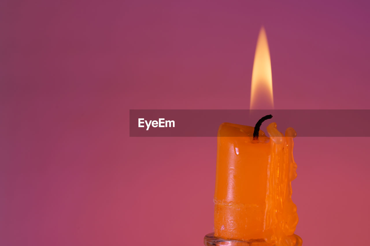 CLOSE-UP OF BURNING CANDLE