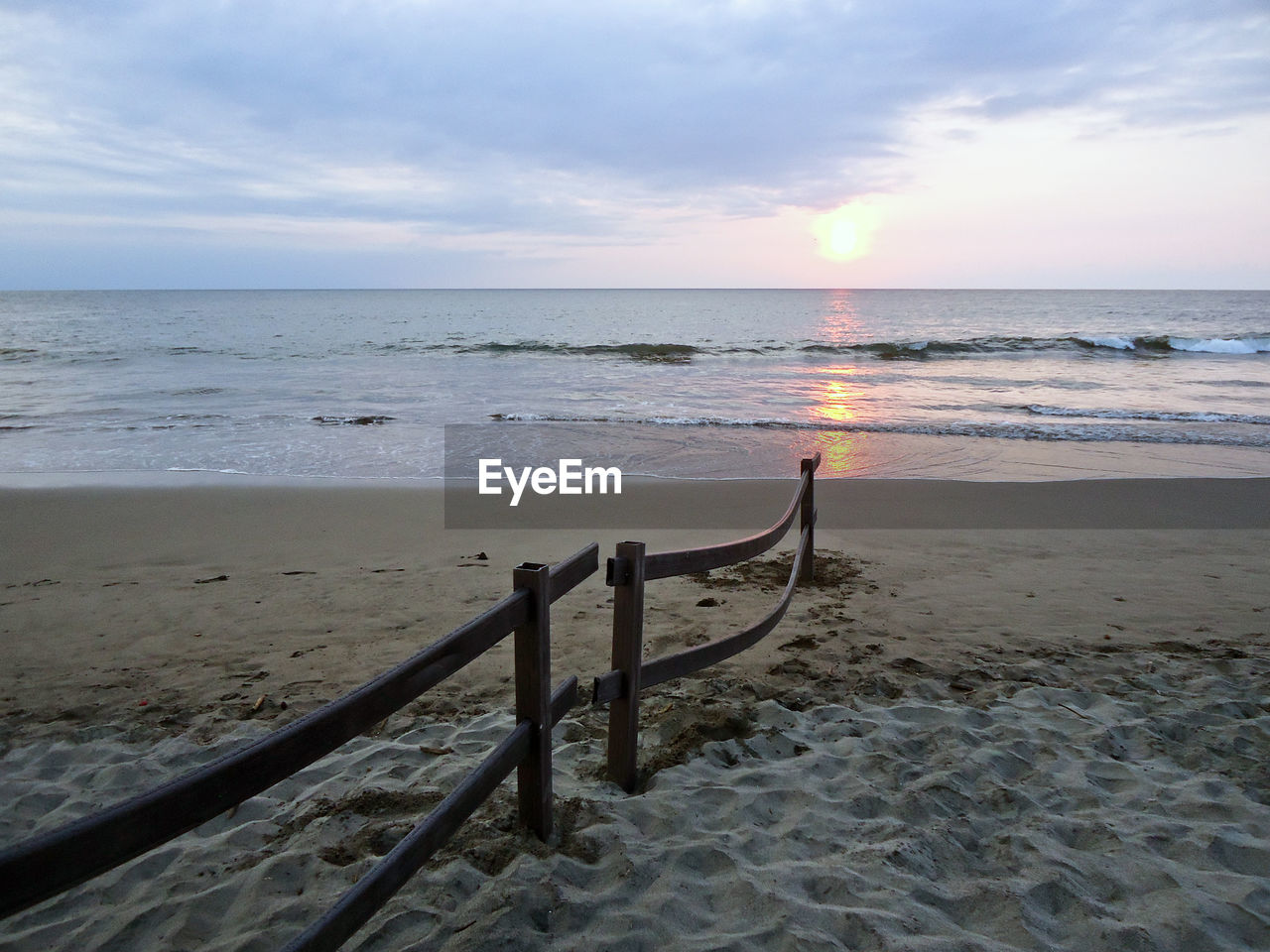 View of calm beach at sunset