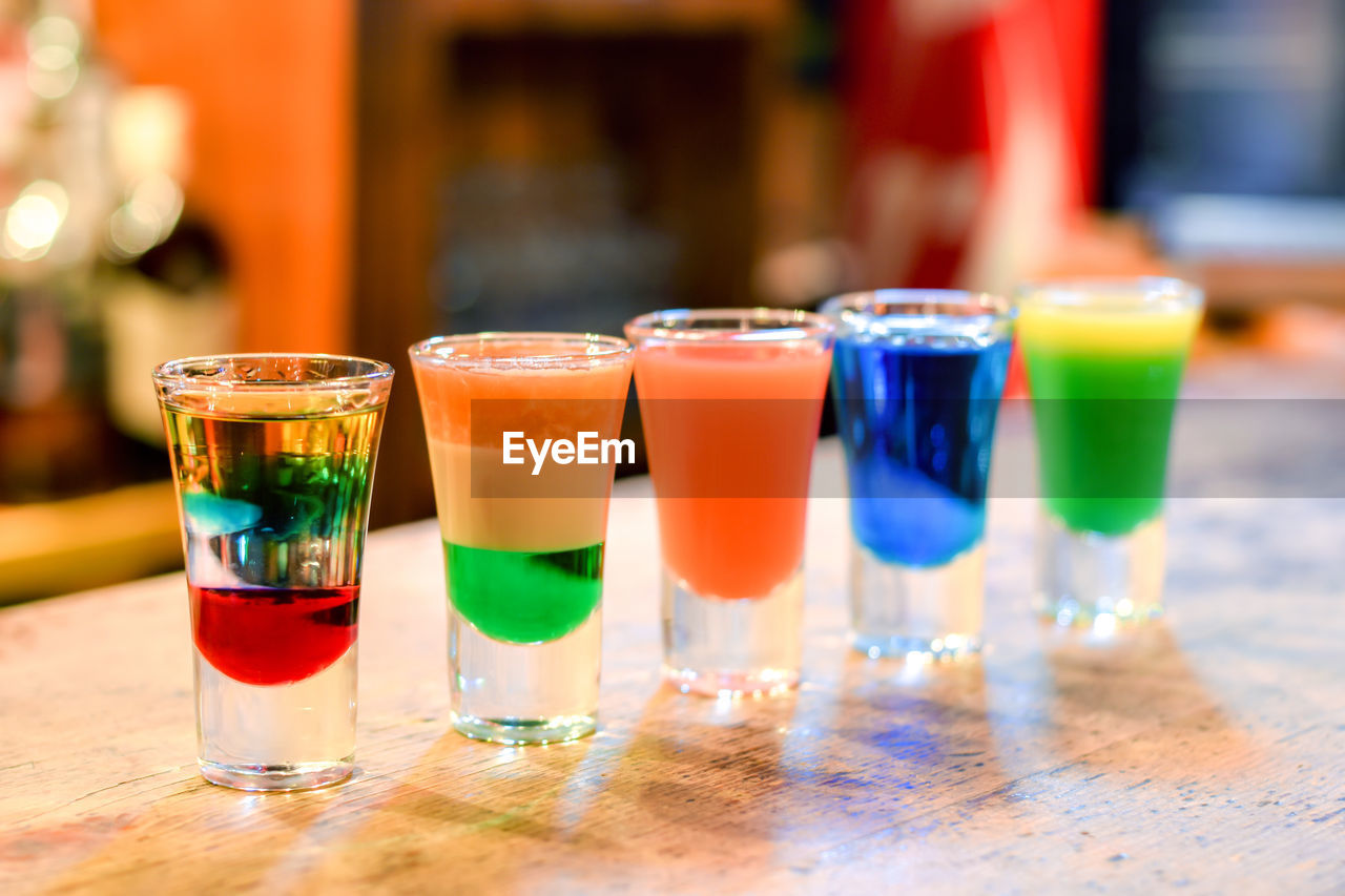 Close-up of colorful cocktail glasses on a bar stand