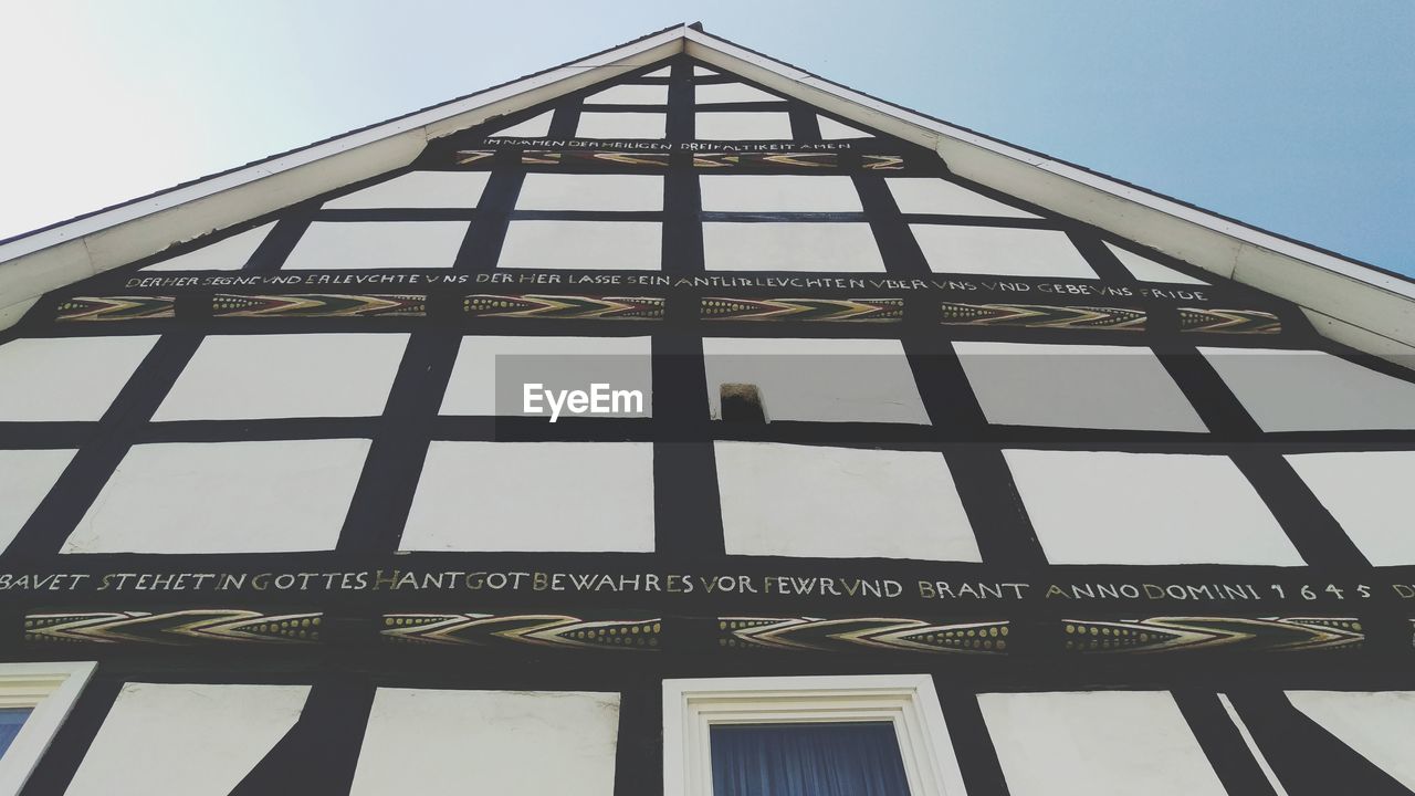 LOW ANGLE VIEW OF SIGN AGAINST BUILDING