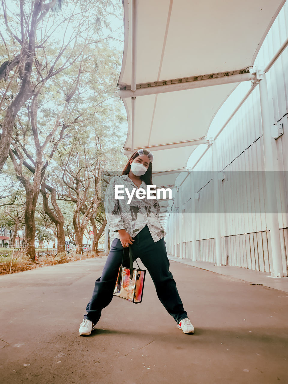 FULL LENGTH PORTRAIT OF YOUNG WOMAN ON SUNGLASSES AGAINST TREE