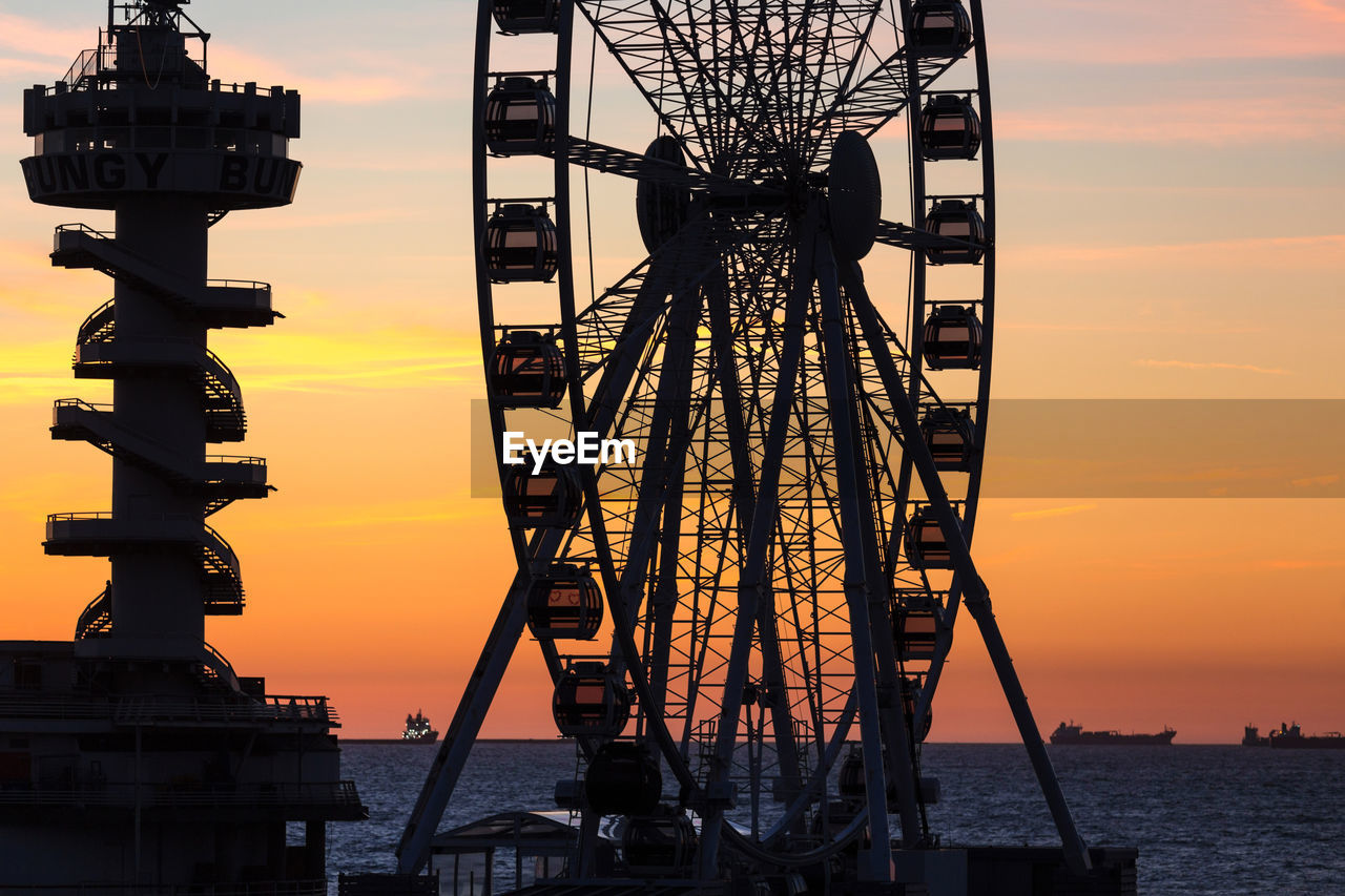 SILHOUETTE CRANES AGAINST ORANGE SKY