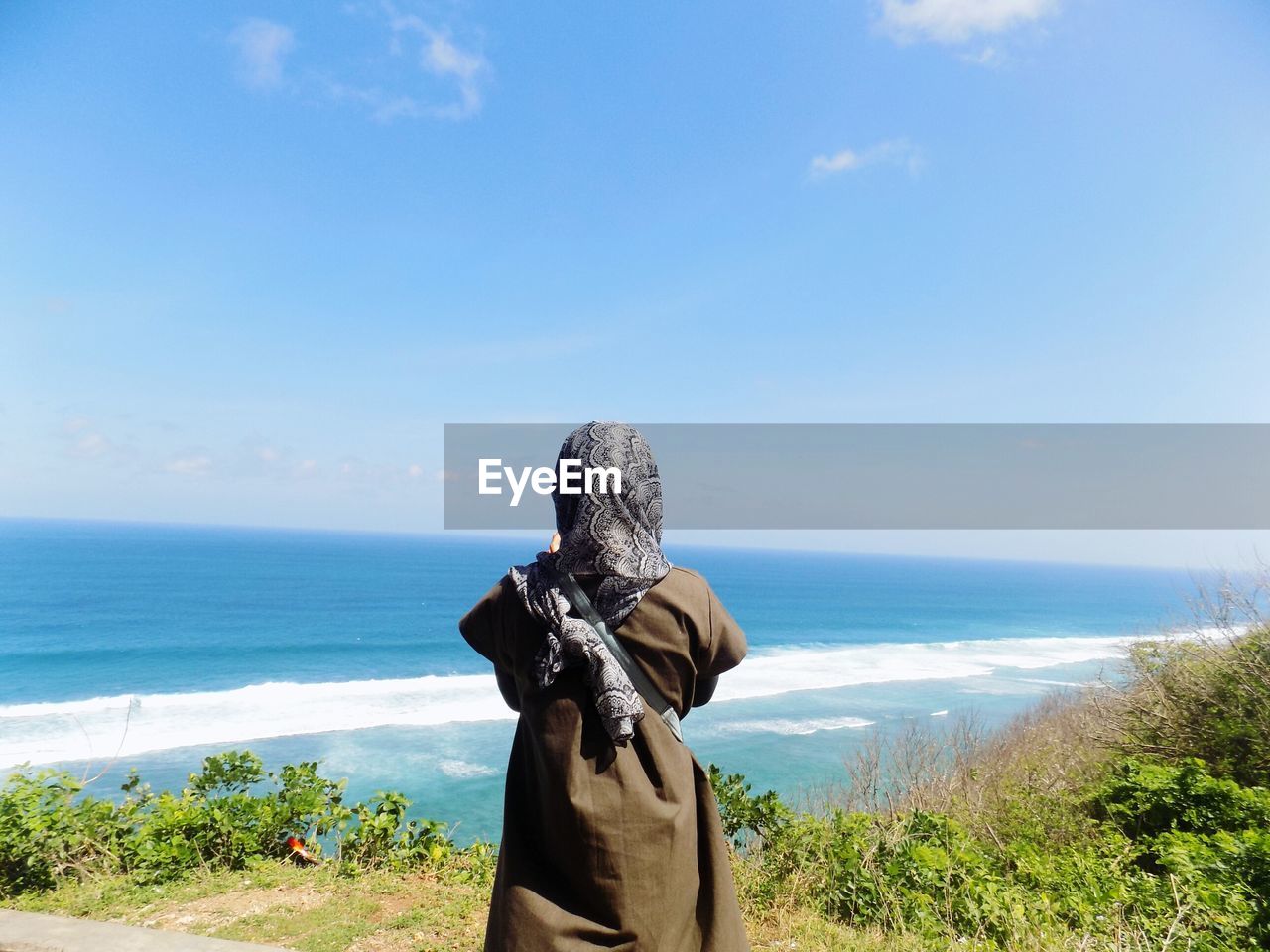 Rear view of woman looking at sea against sky