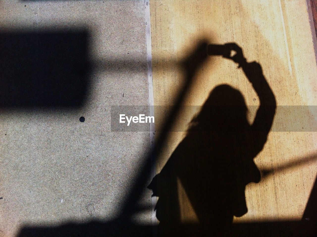 Shadow of woman photographing wall