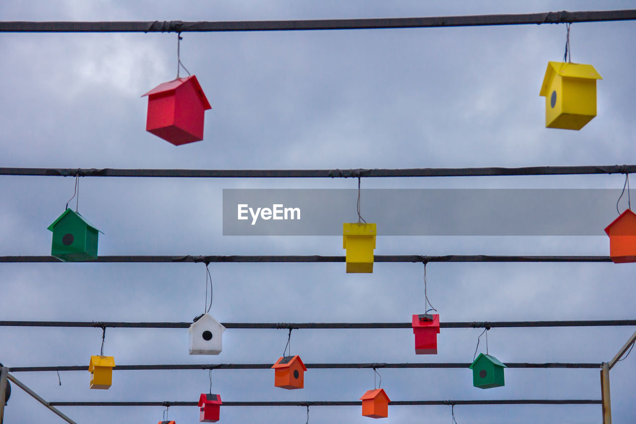 LOW ANGLE VIEW OF MULTI COLORED UMBRELLAS AGAINST SKY