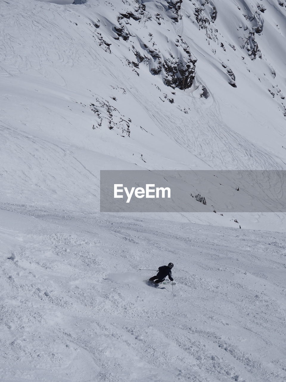 Rear view of person skiing on snowcapped mountain