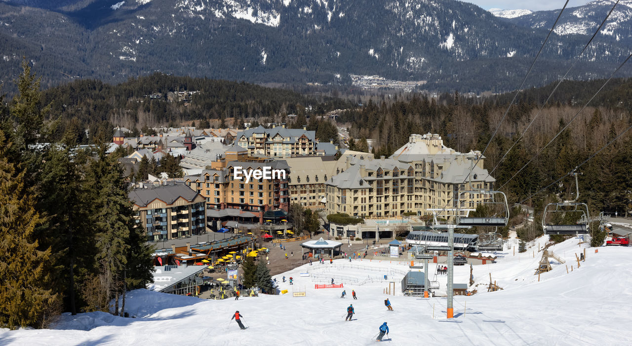 HIGH ANGLE VIEW OF CROWD ON SNOW COVERED BUILDINGS