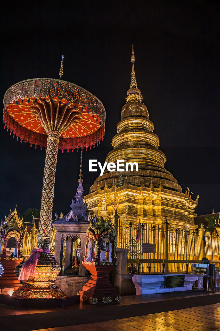 Low angle view of illuminated pagoda against sky at night