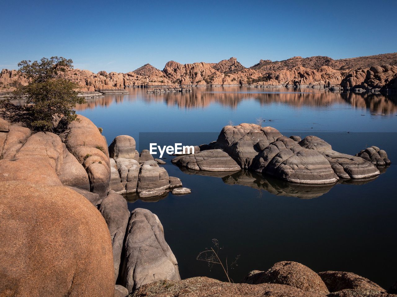 Scenic view of lake against clear blue sky