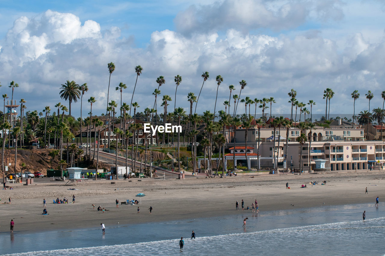 GROUP OF PEOPLE ON BEACH IN CITY