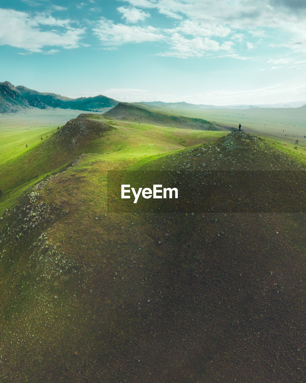 A man stands on a hill in a stunning landscape