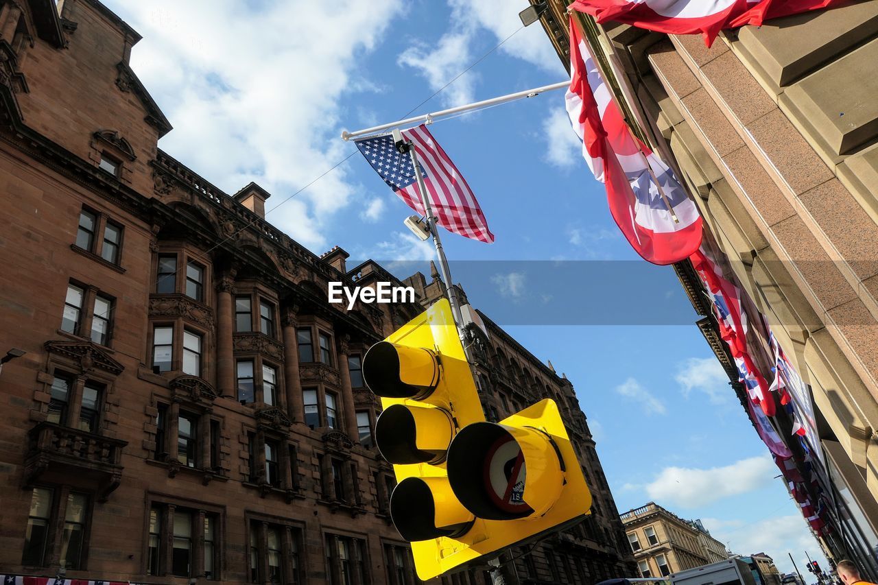 LOW ANGLE VIEW OF FLAG AGAINST BUILDINGS IN CITY