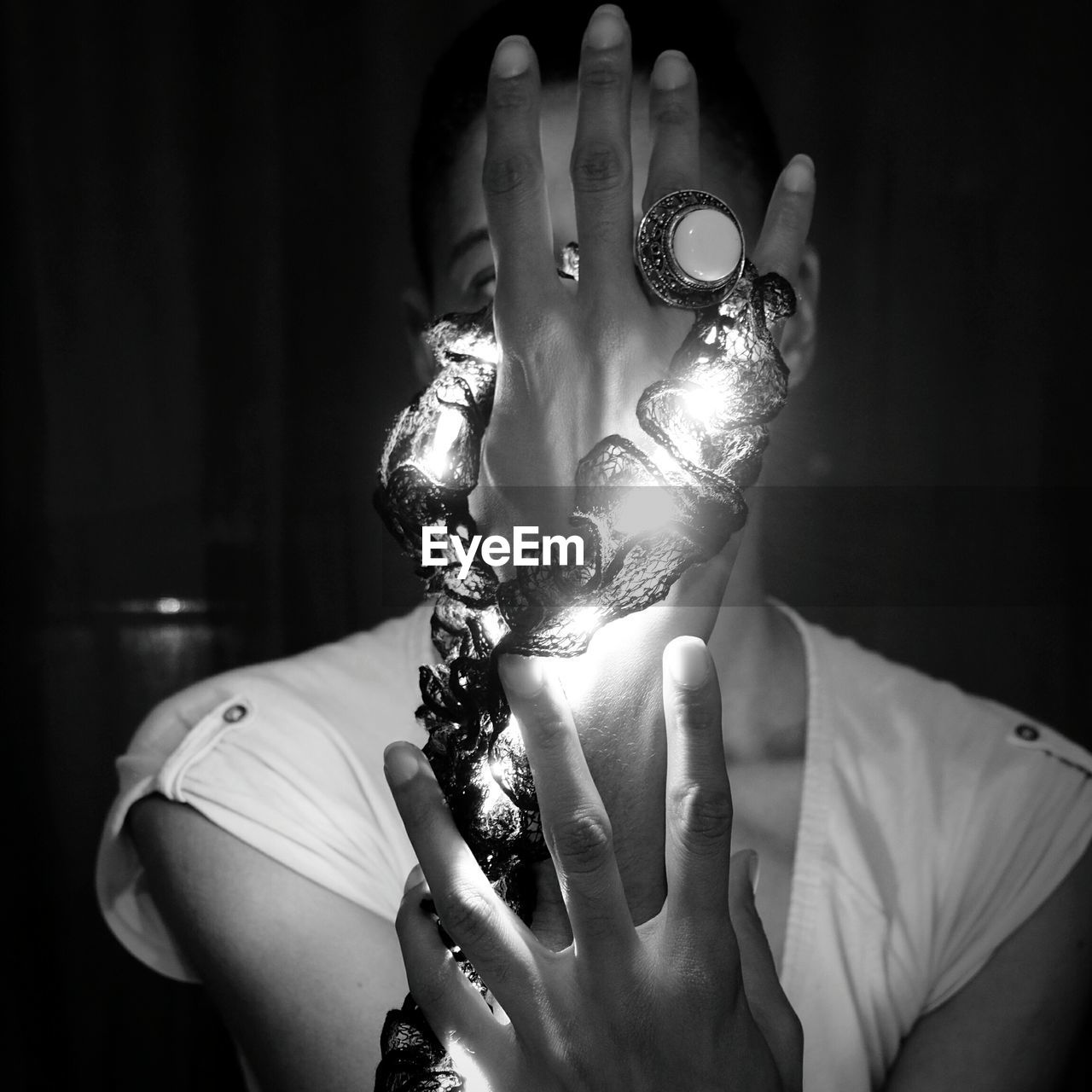 Close-up of woman illuminated led lights in darkroom