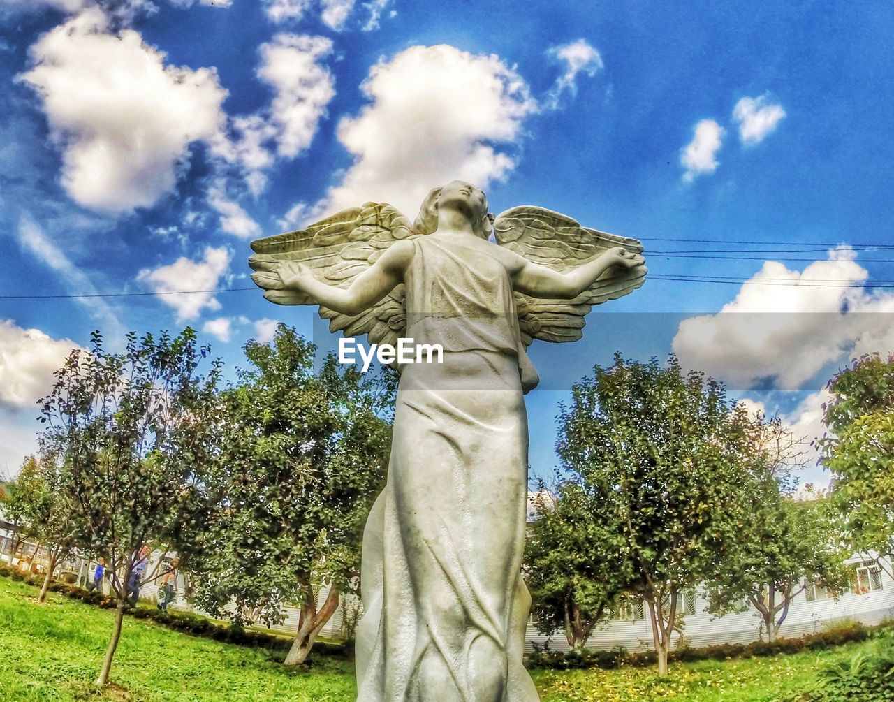 LOW ANGLE VIEW OF STATUE AGAINST TREE